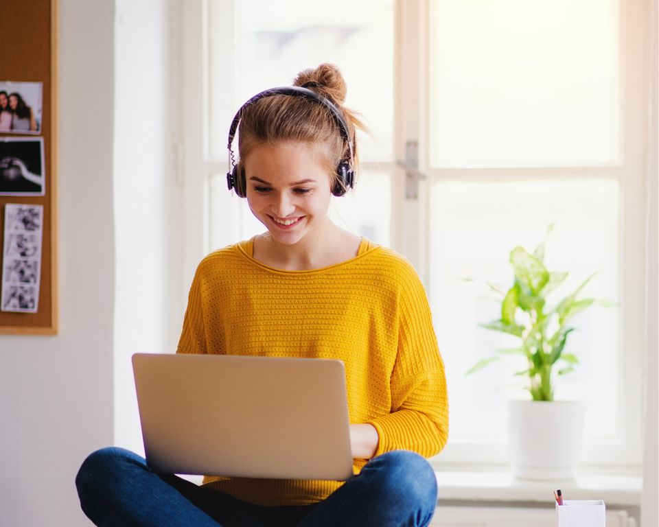 © stock.adobe.com/Halfpoint Junge Frau in gelben Pullover organisiert fröhlich ihre Finanzen am Laptop | © stock.adobe.com/Halfpoint